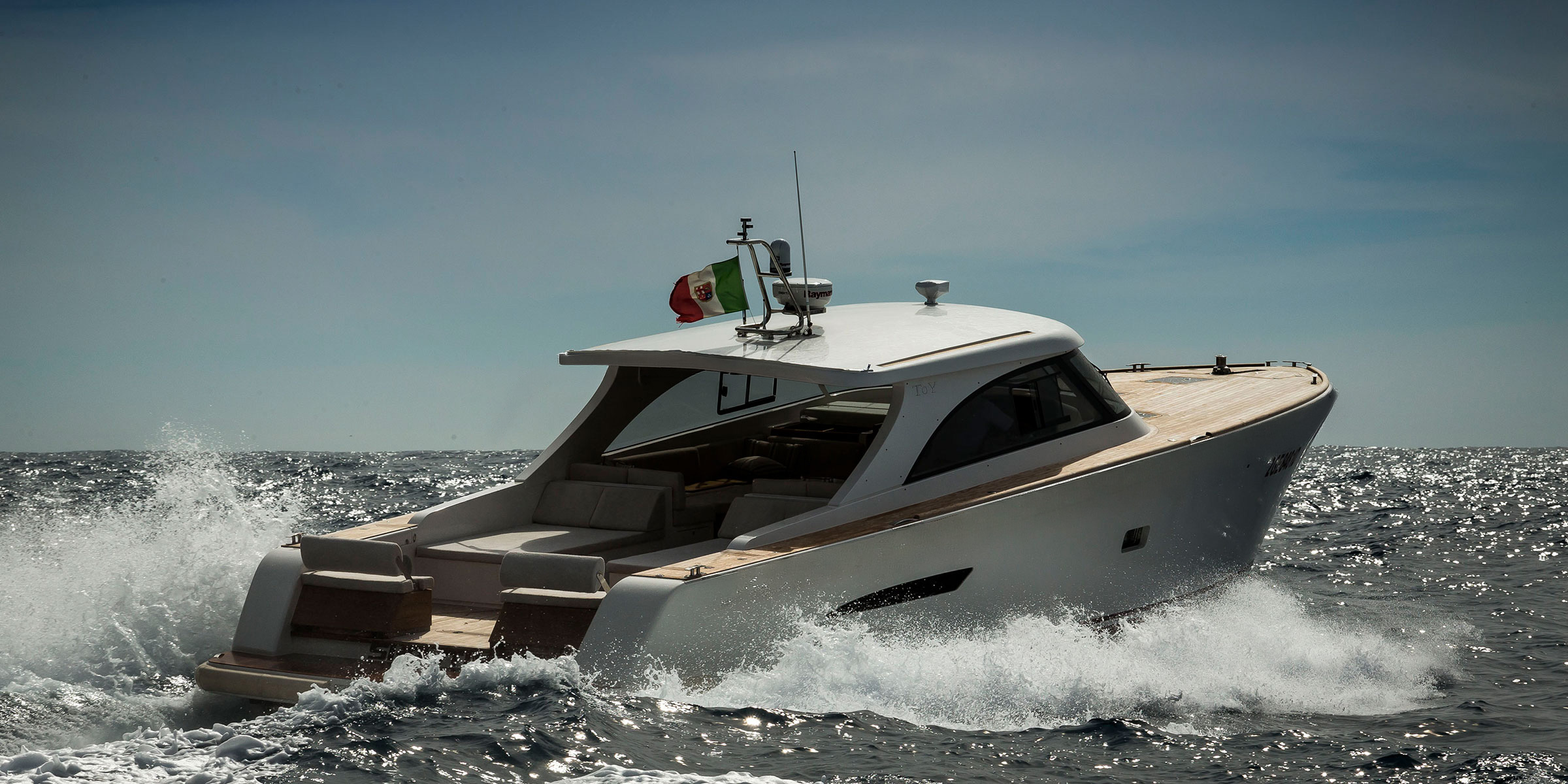 Barca a motore Toy 47 con scafo bianco in navigazione in una bella giornata di sole